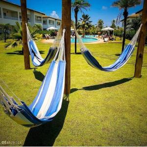 苏巴乌马Apartamento Master VIP com 3 suítes noTree Bies Resort的公园内2张蓝色和白色的吊床,设有游泳池