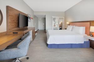 圣奥古斯丁圣奥古斯丁- 维拉诺海滩汉普顿酒店的配有一张床和一台平面电视的酒店客房