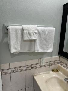 洛杉矶La Cienega Inn Motel的浴室的墙壁上挂着白色毛巾