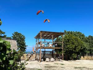 Buen HombreBeach Terrace Loft in Buen Hombre的两只风筝在木结构上飞过天空