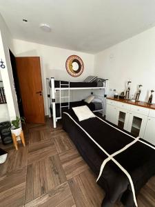 埃塞萨Hospedaje posada en Ezeiza的一间卧室设有一张黑色的床,铺有木地板。