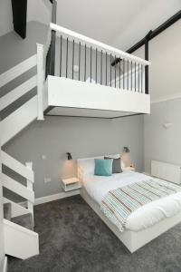GrangeMoran's Bar & B&B的卧室配有白色的床和楼梯。