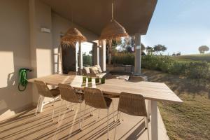 米哈斯科斯塔Chic 3BR Haven - Luxury Ground Floor - La Cala Golf的天井上的木桌和椅子