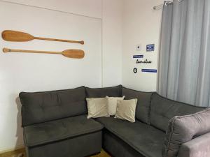 瓜拉派瑞Centro Guarapari - espaço & conforto - WI-FI的客厅配有沙发,墙上挂着木 ⁇ 蝠
