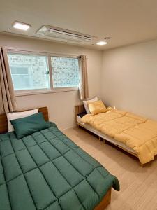 首尔Clean 2 SuperSingle Beds House的一间卧室设有两张床和窗户。