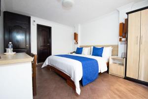 伊瓦拉维多利亚广场酒店的一间卧室配有一张带蓝白色床单的大床