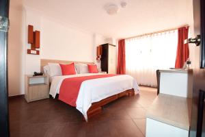 伊瓦拉维多利亚广场酒店的一间卧室配有一张带红色枕头的大床