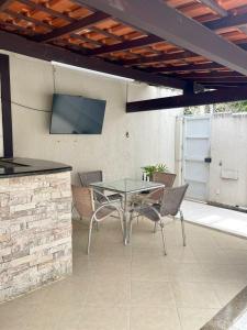 尼泰罗伊Hospedagem Caminho das Praias的庭院配有桌椅和电视。