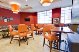 格林维尔格林维尔德鲁里酒店的用餐室配有橙色椅子和桌子