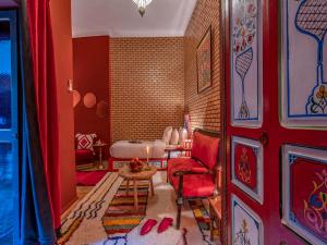 马拉喀什翼哈里娜摩洛哥传统庭院住宅的红色的客厅配有红色椅子和桌子