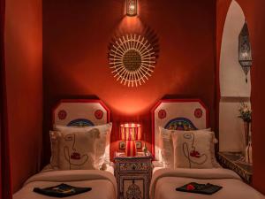 马拉喀什翼哈里娜摩洛哥传统庭院住宅的红色墙壁的客房内的两张床