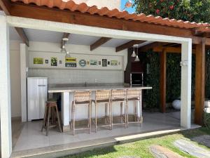 塞古罗港Casa da Jana com piscina的室外厨房,配有带凳子的酒吧