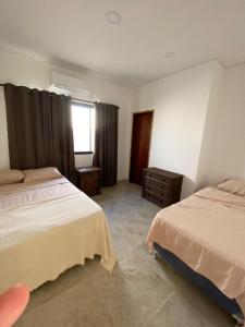 圣贝纳迪诺San ber puerta del lago 4 dormitorios en suite的一间卧室设有两张床和窗户。