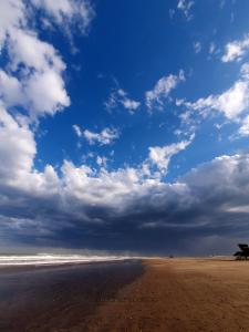 马德普拉塔Casa a estrenar en Mar del Plata proximo a Mogotes, a las playas del sur y cerca del Faro的一片云天和海洋的海滩