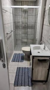 普雷图河畔圣若泽Wana casa 4 -Requinte e Conforto的带淋浴、卫生间和盥洗盆的浴室