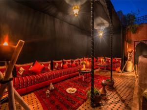 马拉喀什翼哈里娜摩洛哥传统庭院住宅的一间客厅,在帐篷里配有红色沙发