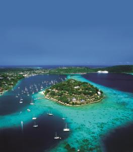 维拉港伊利利奇岛Spa度假酒店的海中的一个岛屿,水中有船只