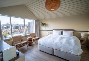 弗吕济The Hill Hotel at Flúðir的卧室设有白色的床和大窗户