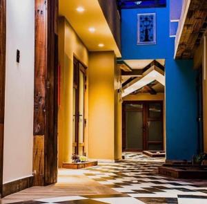 拉塞雷纳Hotel boutique的走廊上设有黄色和蓝色的墙壁和 ⁇ 格地板