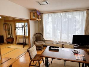 东川町民宿にしかぐら的客厅设有桌子和大窗户