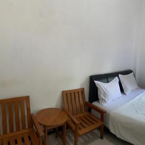 帕朗卡拉亚Hotel Nascar Famili的卧室配有一张床和一张桌子及椅子