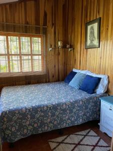 Río CuartoEquipped cottage in Laguna Hule的卧室配有木墙内的一张床