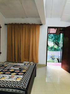 明内里耶Randiya Holiday Resort的一间带床的卧室,位于带窗户的房间内