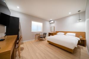 水原市MONO HOTEL的一间卧室配有一张床、一张书桌和一台电视