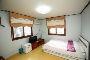 济州市Jun Motel的一间卧室配有一张床和一台电视。