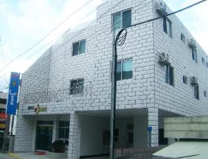 济州市Jun Motel的前面有路灯的白色砖砌建筑