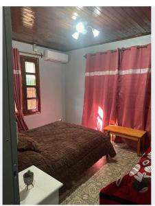 伊瓜苏港Parana house的一间卧室配有床和红色窗帘