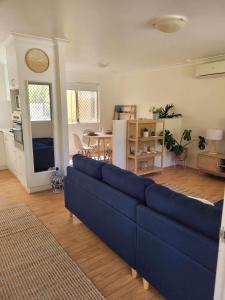 WarnbroG&R Beach Cottage的客厅配有一张蓝色的沙发,配有一张桌子