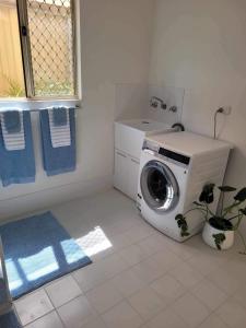 WarnbroG&R Beach Cottage的一间带盥洗盆的浴室内的洗衣机