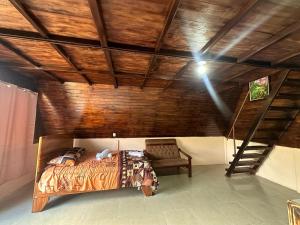 San RafaelBungalow Tenorio Mountain Lodge的一间卧室设有一张床和木制天花板