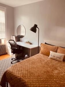 UnionportPrivate Rooms in TownHouse w Shared Baths Qn Bed 1-3ppl的一间卧室配有一张带书桌和灯的床。