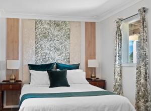 斯普林伍德Mapleton Park Cottage的一间卧室设有一张大床和一个窗户。
