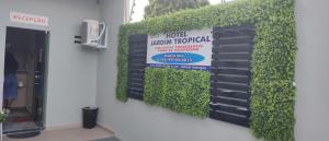 博阿维斯塔Boa vista, Hotel Jardim Tropical的建筑前有标志的绿色墙