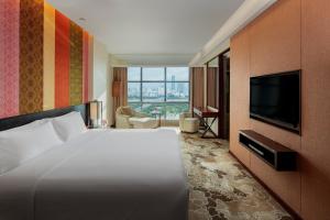 柳州柳州丽笙酒店的配有一张床和一台平面电视的酒店客房