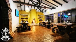莱瓦镇La Villa de San Sebastian Hotel的一间带木桌和壁炉的餐厅