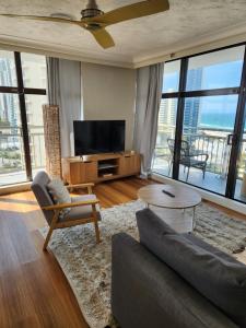 黄金海岸Beachcomber Resort - Deluxe Rooms的带沙发和电视的客厅