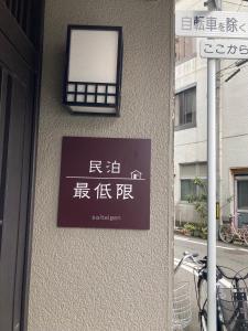 福井福井駅から徒歩2分の1棟貸切民泊 最低限的建筑一侧的标志,带有窗户