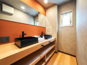 福冈Rakuten STAY Hakata Gion 302 - Rakuten Ichiba Collaboration Room -的浴室设有黑色水槽和橙色墙壁。