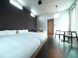 福冈Rakuten STAY Hakata Gion 101 Superior Room的卧室配有2张白色的床和桌子