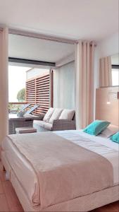 卡普戴尔RIVIERA Appart'hôtel Panoramique的一间卧室配有一张大床和一张沙发