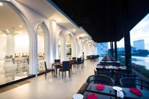 芽庄Champa Island Nha Trang - Resort Hotel & Spa的一间带桌椅的河景餐厅
