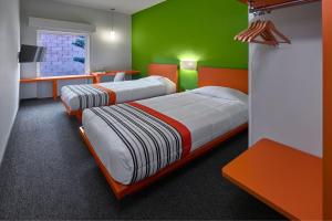 托卢卡City Express Junior by Marriott Toluca Aeropuerto的绿色和橙色客房的两张床