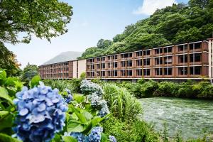 箱根Hotel Indigo Hakone Gora, an IHG Hotel的鲜花盛开的河前建筑