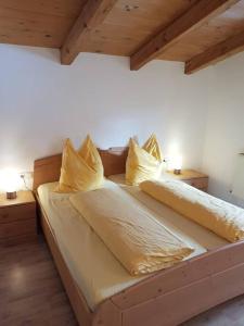 NiederndorferbergGemütliche Wohnung mit Blick auf den Zahmen Kaiser的一张带黄色床单和枕头的床