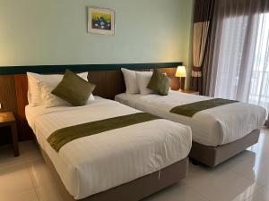 清盛暹罗三角酒店的两张床铺位于带衬衫的酒店客房内