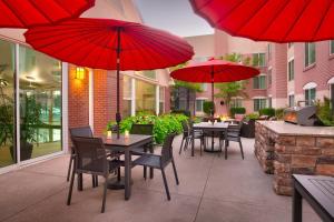桑迪盐湖城桑迪公寓的一个带桌椅和红伞的庭院